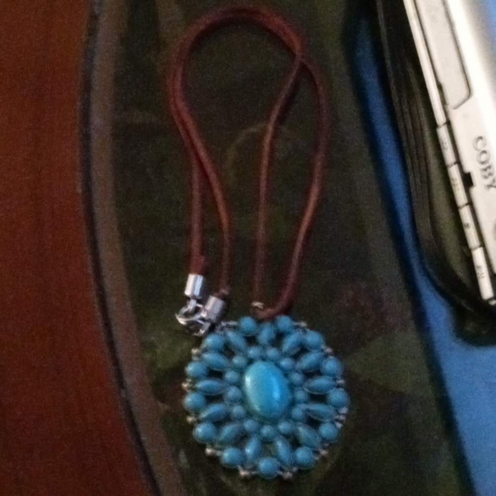 Metal turquoise pendant on leather brown cord